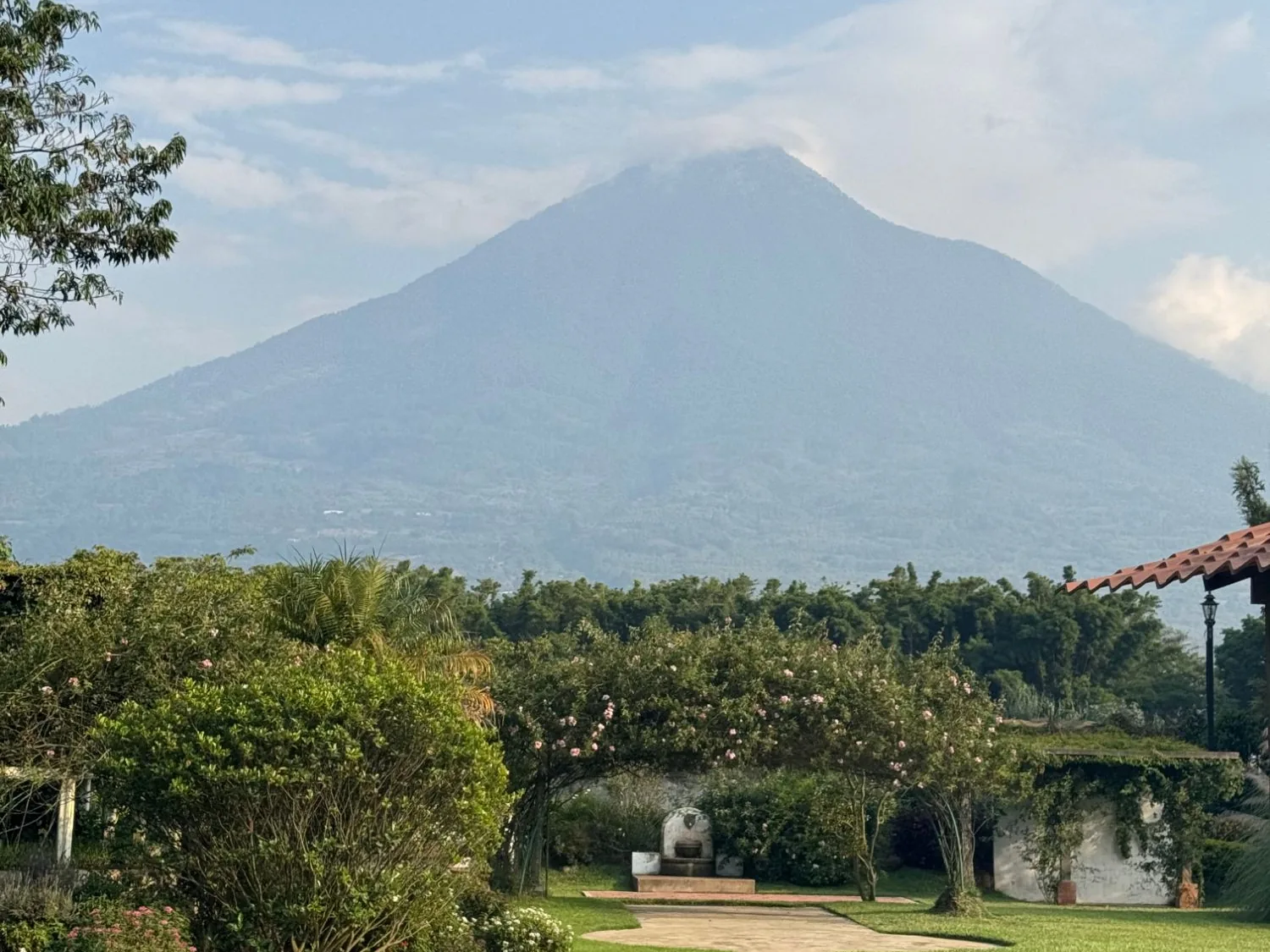 Jardín con arco de flores y el Volcán de Agua al fondo